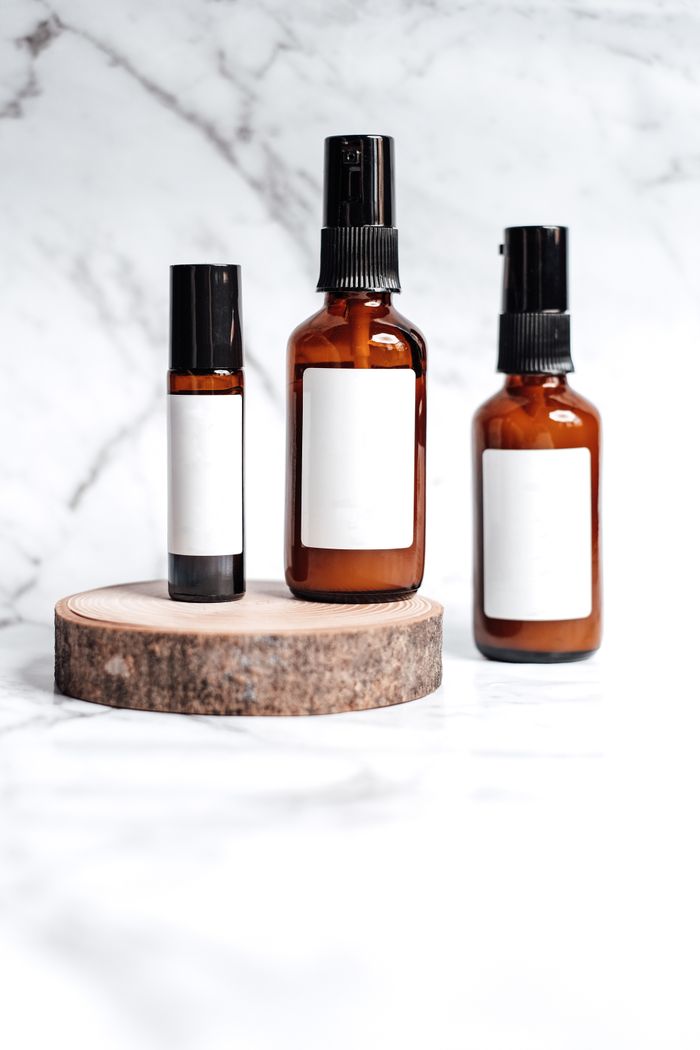 who-we-are Brown glass bottles for skincare products on a marble background.